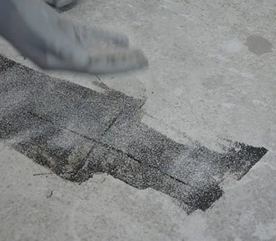 Spargimento della sabbia di quarzo nella resina appena versata.