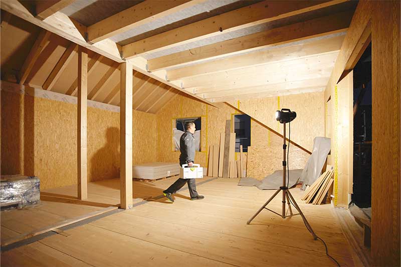 Un faro da cantiere illumina una stanza buia e priva di finestre