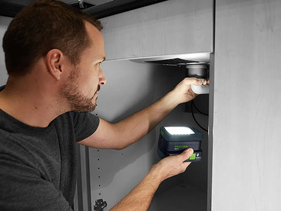 Un uomo illumina il collegamento di un lavabo con il SYSLITE KAL 2